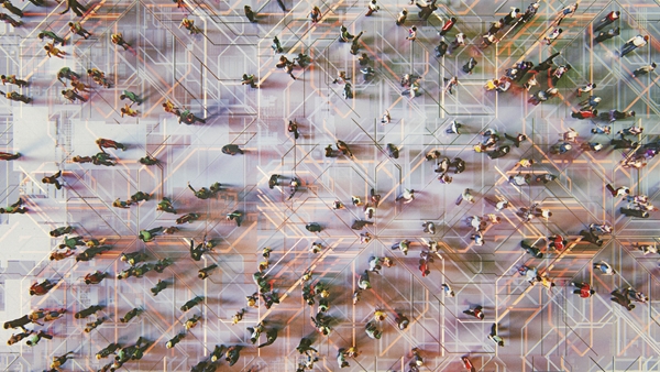 An overhead shot shows a diverse crowd of people walking on a translucent, glowing circuit board design.
