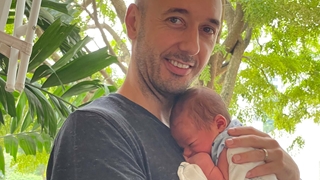 Garry holding Avi on parental leave