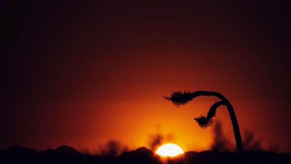 Sunset over a desert landscape, with vibrant colors in the sky