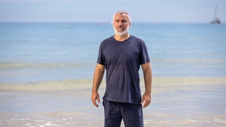 Paul standing on a beach