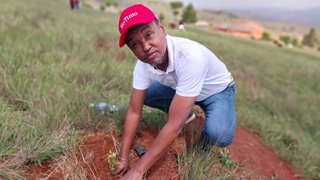 A member of community touching soil