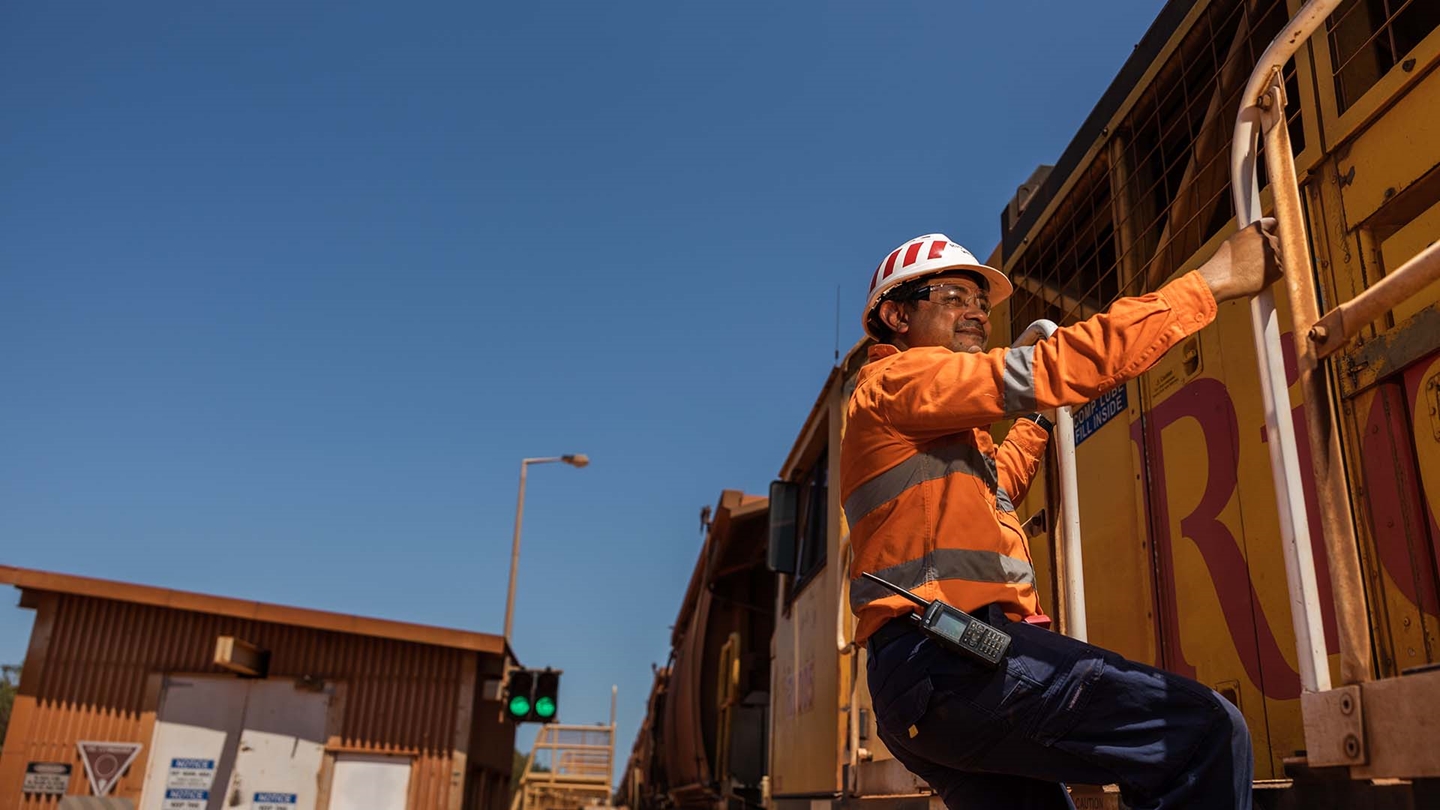 Indigenous employee maintaining 3 point contact on locomotive, Weipa Operations
