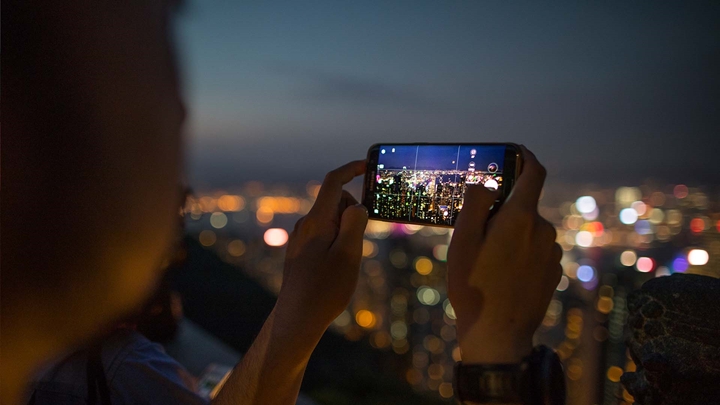 A picture of the Hong Kong Skyline with a smartphone from "The Peak" viewing area
